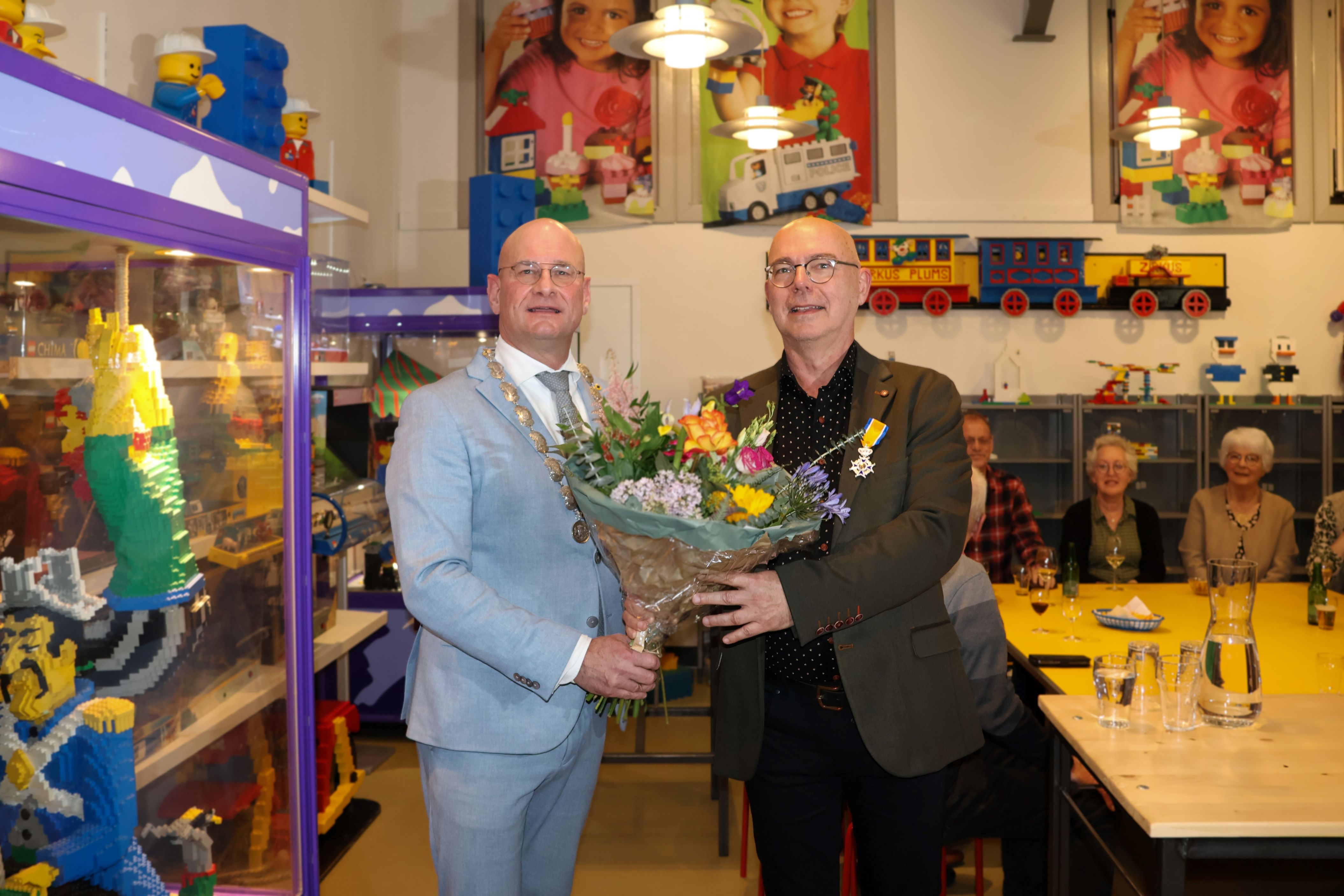 Burgemeester Jan Nieuwenburg overhandigt Hans Stuijfbergen bloemen na het opspelden van de Koninklijke onderscheiding